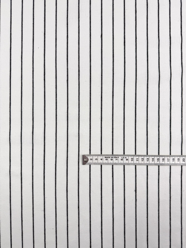 Super Cheap Fabrics’ Linen Blend - Classic Chalk Pinstripe (135cm) features a lightweight linen fabric with evenly spaced vertical black stripes on white. A measuring tape shows measurements from 0 to 30cm across the lower part.