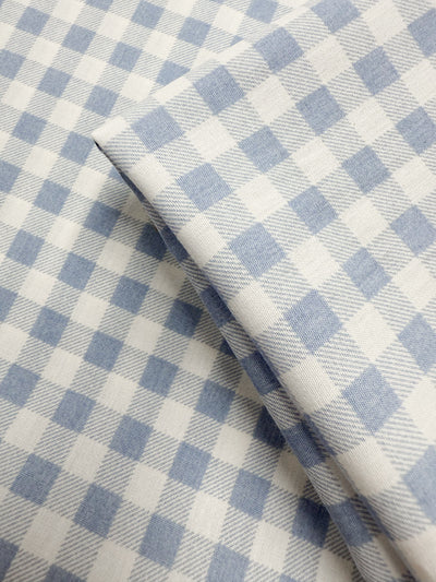 A close-up of Super Cheap Fabrics' Linen Blend - Powder Blue Picnic (140cm), featuring soft light blue and white gingham checks—an ideal lightweight linen blend for summer jackets.