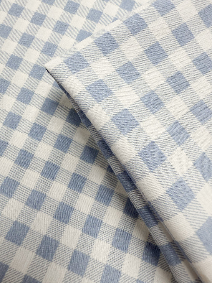 A close-up of Super Cheap Fabrics' Linen Blend - Powder Blue Picnic (140cm), featuring soft light blue and white gingham checks—an ideal lightweight linen blend for summer jackets.