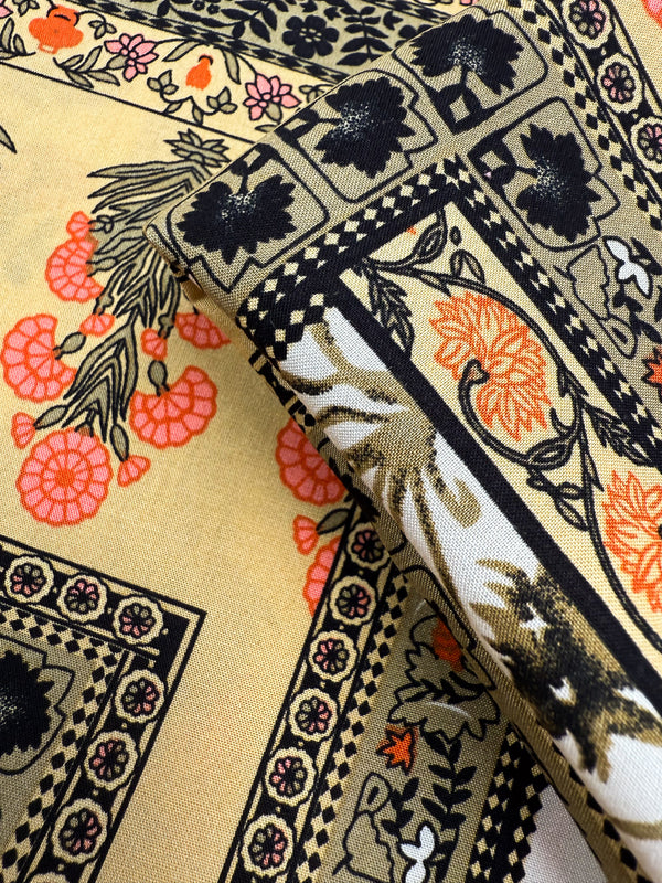 A close-up of Designer Rayon - Antique Tapestry by Super Cheap Fabrics shows folded, vibrant rayon with floral and geometric patterns in black, orange, and pink on beige, featuring flowers, leaves, and decorative borders. Width: 145cm.