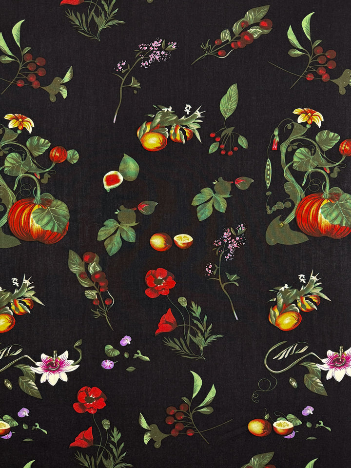 Designer Rayon - Dark Orchard Bloom by Super Cheap Fabrics features colorful illustrated flowers, leaves, pumpkins, berries, and citrus fruits on black—creating a vibrant botanical pattern perfect for lightweight rayon fabric. Width: 145cm.
