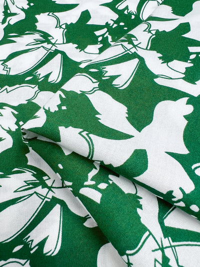 Abstract green and white Designer Rayon fabric by Super Cheap Fabrics, called First Tee, features overlapping bird silhouettes with vibrant prints on a 140cm width.