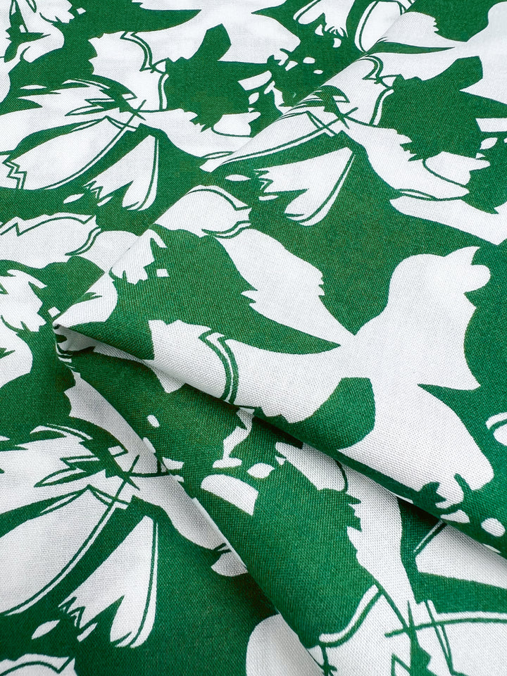 Abstract green and white Designer Rayon fabric by Super Cheap Fabrics, called First Tee, features overlapping bird silhouettes with vibrant prints on a 140cm width.