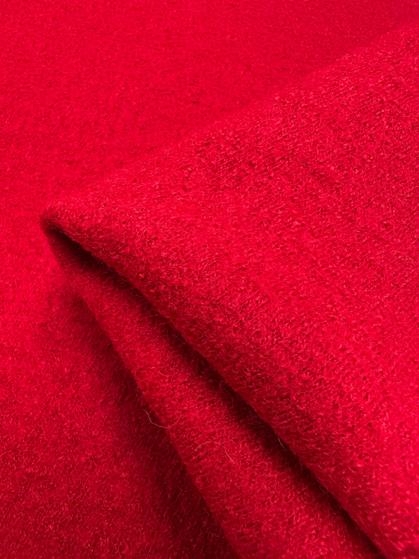 Close-up of Super Cheap Fabrics' Boiled Wool in Racing Red, 145cm wide, showing its thick wool-like texture with a folded corner—ideal for winter garments.