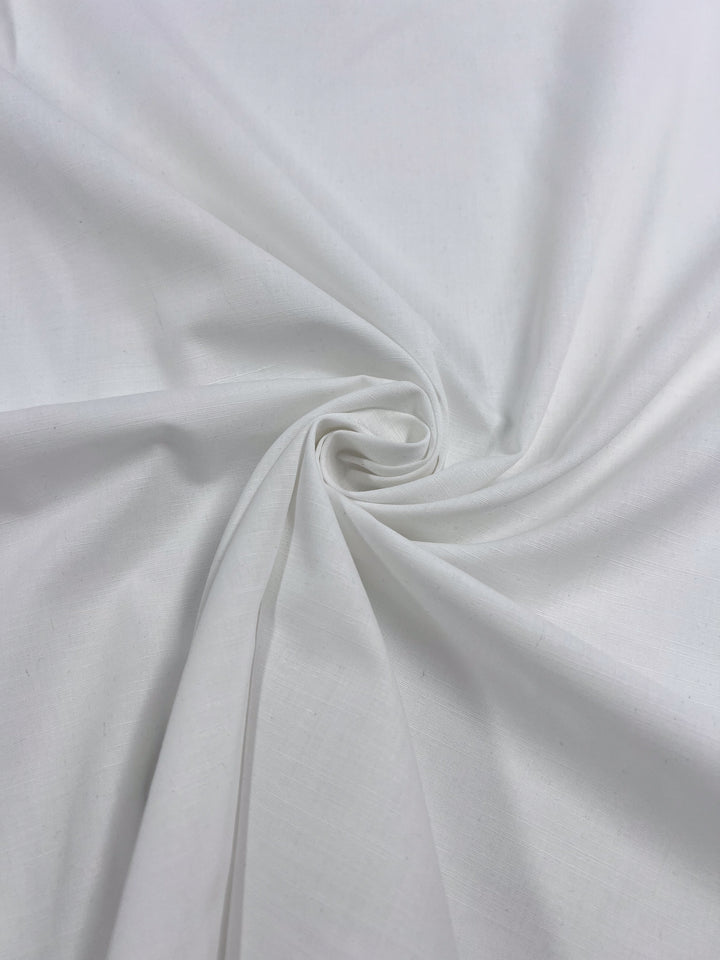 The Poplin - White - 148cm by Super Cheap Fabrics features a centered swirl pattern on lightweight polyester cotton, creating a twisting effect. Perfect for childrenswear, it is smooth and soft with lighting that beautifully highlights the texture.