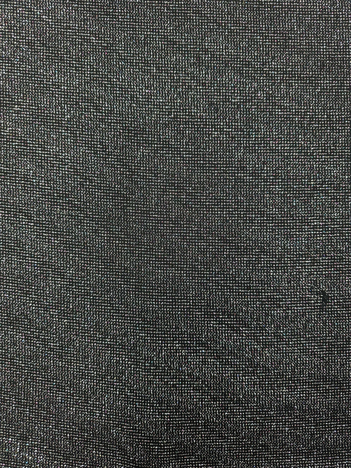 The Metallic Lycra - Disco from Super Cheap Fabrics is a medium-weight dark gray material with a textured finish and subtle sheen. Its tight weave creates a uniform pattern, perfect for stylish dresses.