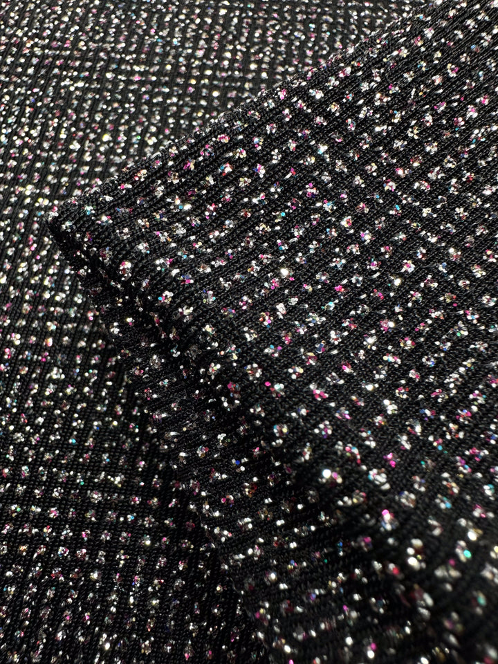 Close-up of Super Cheap Fabrics' Metallic Lycra - Disco, a 150cm medium-weight fabric with a ribbed pattern and glittery multi-colored specks, folded to display its ideal texture and shine for dresses.