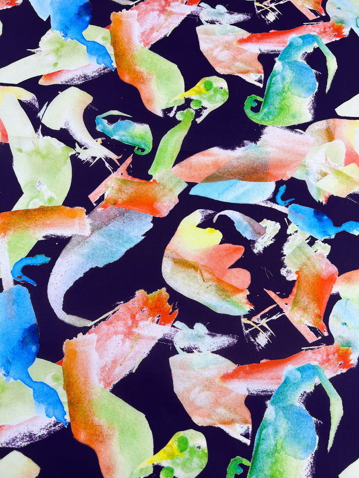 The Printed Cotton - Chiken - 150cm by Super Cheap Fabrics features vibrant shades of green, orange, blue, and pink on a dark base. Its dynamic brushstrokes blend soft and bold patterns reminiscent of lively cotton fibers.