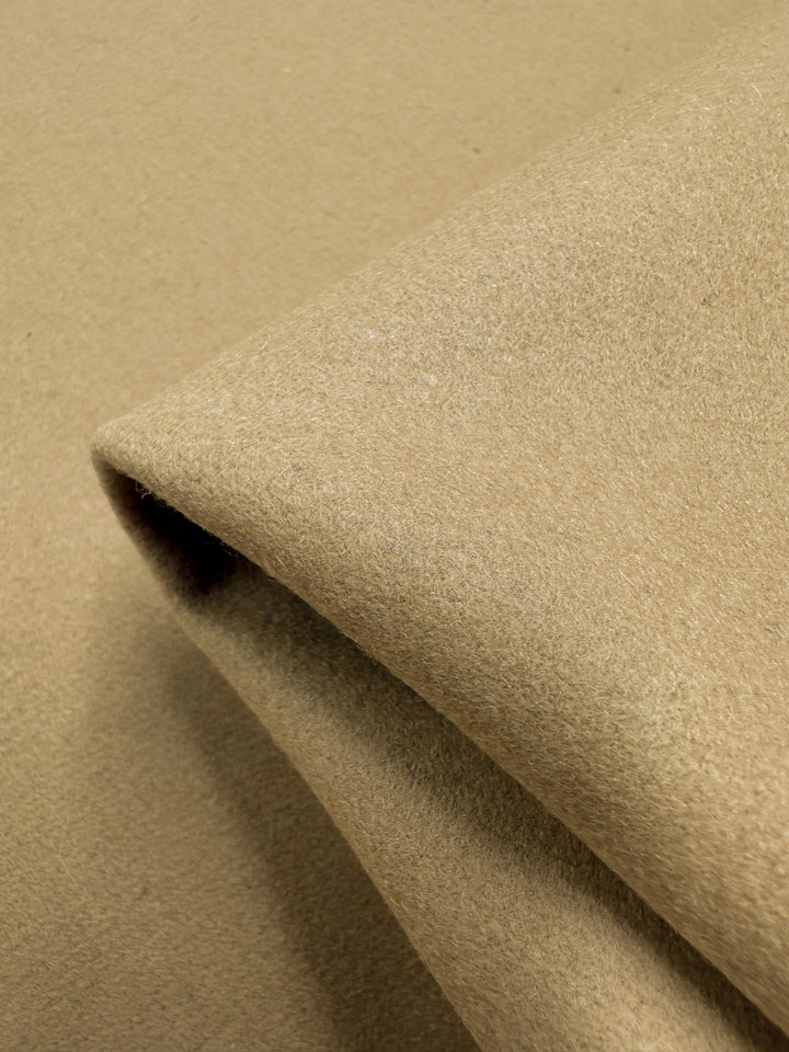 A close-up of the folded Super Cheap Fabrics' Merino Wool in Curd & Whey (150cm) showcases its soft, textured surface. The fabric appears thick and slightly fuzzy, suggesting warmth and comfort.