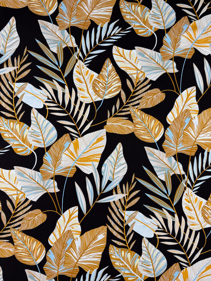 Bamboo Rayon - Tropic Gold by Super Cheap Fabrics features a seamless pattern of golden yellow and light blue tropical leaves on black—ideal for lightweight sewing projects or beginners. Width: 150cm.