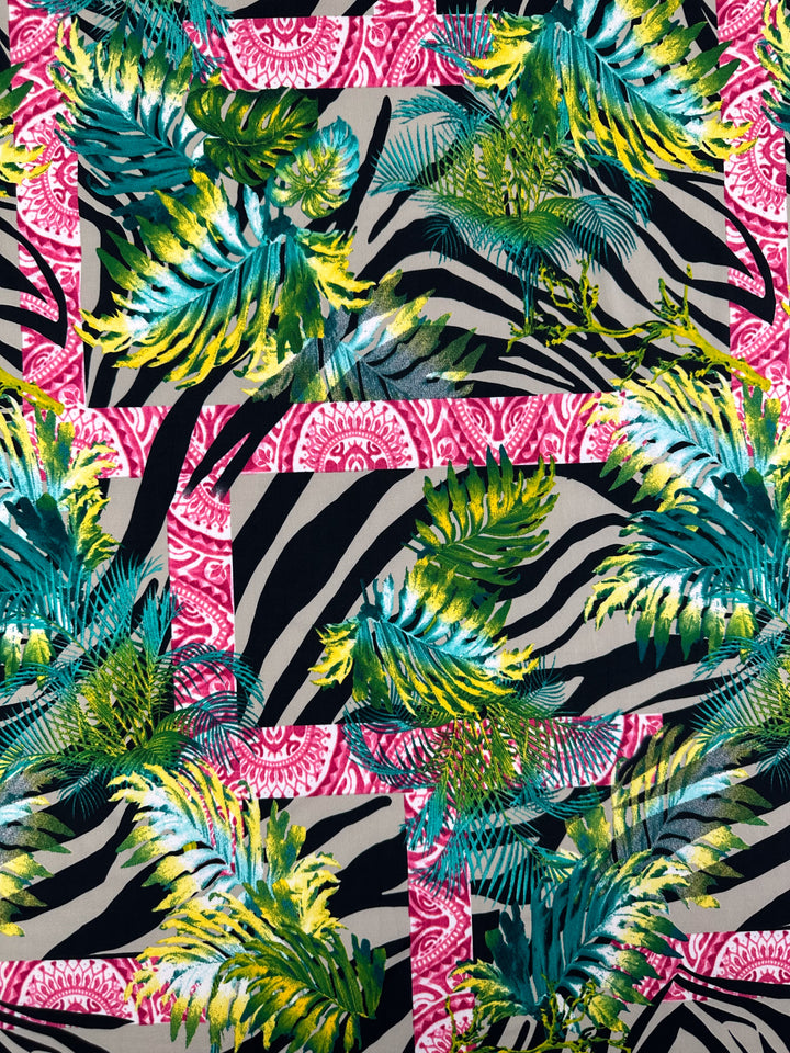 The Super Cheap Fabrics' Printed Lycra - Jungle Frame - 145cm features a vibrant pattern with green and yellow tropical leaves over zebra stripes and pink paisley. Made from Polyester/Spandex, it offers a lively, exotic look with two-way stretch for comfort.