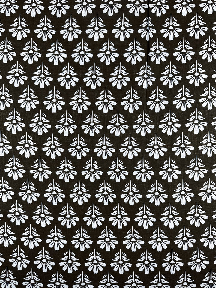 The Linen Blend - Chambray Floretta by Super Cheap Fabrics features black fabric with symmetrical white floral motifs in a uniformly spaced pattern, crafted from a breathable linen-cotton blend. Width: 138cm.