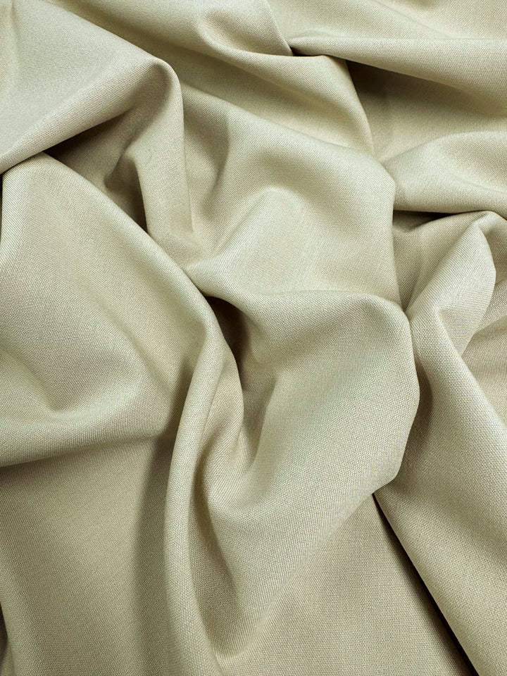 A close-up of Super Cheap Fabrics' Deluxe Suiting in Brown Rice (150cm), a medium weight polyester fabric with a smooth texture, shown loosely draped to create soft folds and creases.