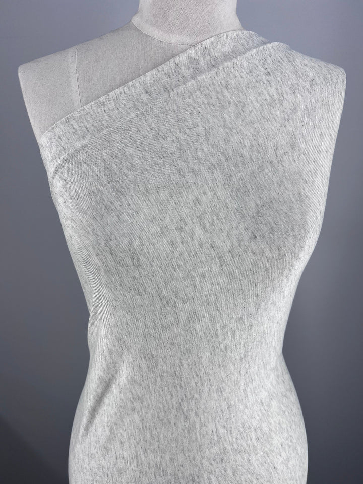 The Summer Cotton Knit - Grey Marle by Super Cheap Fabrics, shown draped diagonally over a dress form against a plain backdrop, highlights its soft cotton texture with excellent stretch recovery.