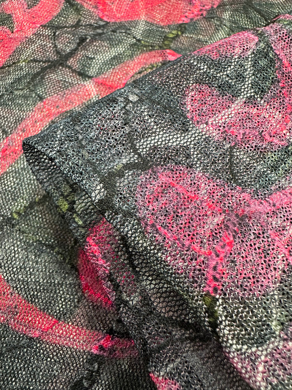 Close-up of Super Cheap Fabrics' Designer Mesh - Delicate - 150cm, made from lightweight polyester with floral lace featuring pink, black, and gray patterns. The intricate design adds layered textures and a delicate woven look, ideal for multi-use applications.