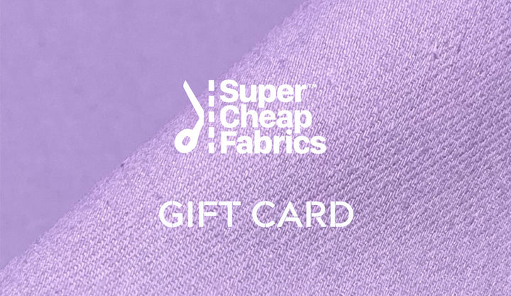 A close-up of a purple fabric with the text "Super Cheap Fabrics" and "Gift Vouchers" printed in white. The brand logo, consisting of a needle and thread design, is situated above the text. Perfect for any sewing enthusiast, these Super Cheap Fabrics Gift Vouchers can be easily redeemed online.